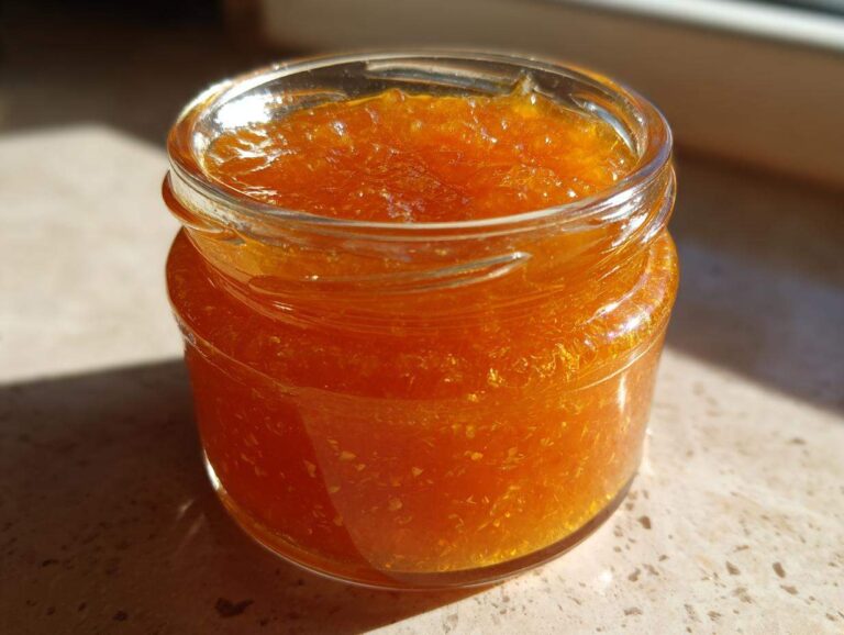 Divine Apricot Jam with Vanilla Lemon in 1 Minute Close-up of a small glass jar filled with bright orange Apricot Jam with Vanilla Lemon.
