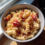 Close-up of a serving of creamy BLT Pasta Salad featuring fusilli pasta, bacon bits, and cherry tomatoes.