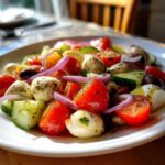Close-up of fresh ingredients like cherry tomatoes, mozzarella balls, and red onion, perfect for a quick Pasta Salad.