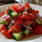 Close-up of a refreshing Cucumber Onion and Tomato Salad featuring diced tomatoes, cucumbers, and red onion.