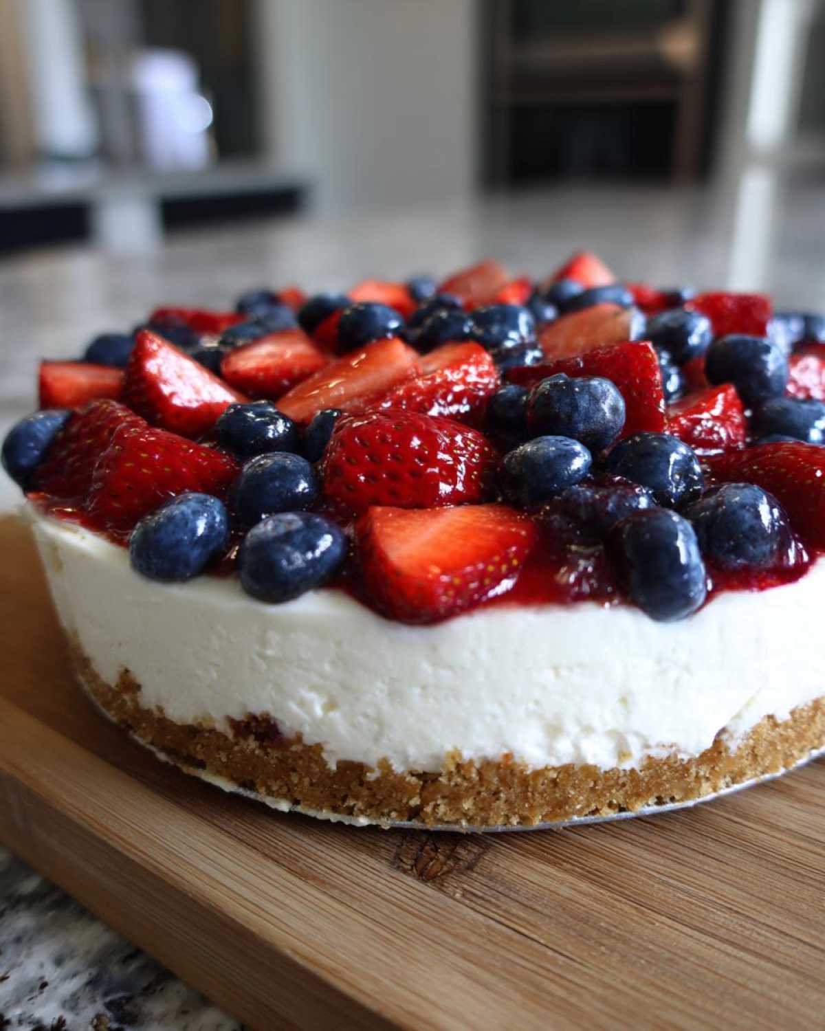 A close-up of the Red, White & Blue Cheesecake Dip topped generously with fresh strawberries and blueberries.