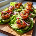 Close-up of finished Sheet Pan Chili-Lime Shrimp Lettuce Wraps topped with avocado crema and radish slaw.